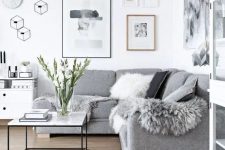 24 a Scandinavian living room done in white and greys, faux fur and pillows add coziness to the space
