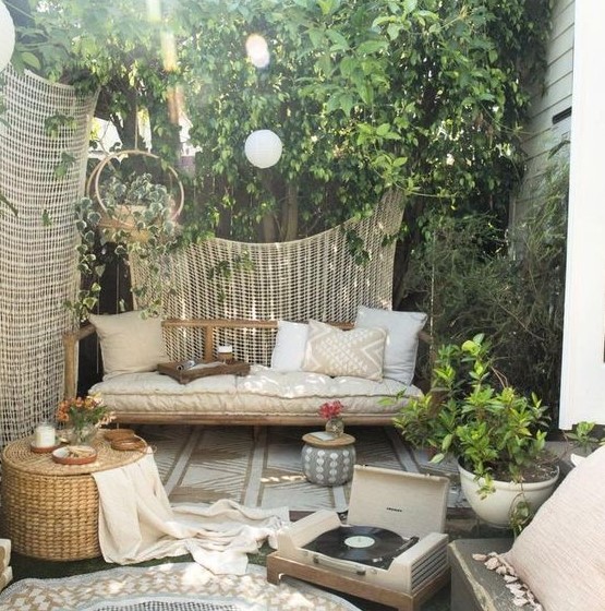 a rattan outdoor daybed under a tree to avoid much sunshine is a perfect fit for a neutral boho zone