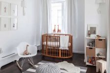28 a serene Scandi nursery with a rich-stained crib and all the rest done in grey and white, with a grid gallery wall and some lovely toys