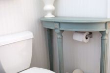 a small powder room with a half table