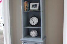 29 a light blue grandfather clock with open storage shelves with some decor and books plus a monogram is a stylish idea