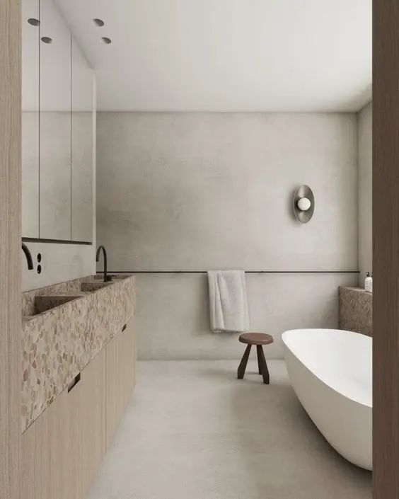 a wabi-sabi bathroom with limewashed walls, a neutral vanity with tan terrazzo sinks and some negative space for an airy feel