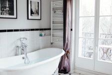 31 a refined Parisian bathroom with a clawfoot bathtub, a crystal chandelier, purple curtains, a gallery wall and negative space to enjoy the  airy feel