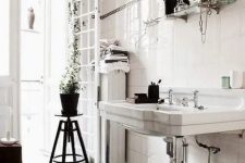 31 a vintage Nordic bathroom done in a neutral color scheme, a vintage stool, sink and a mirror with a shelf