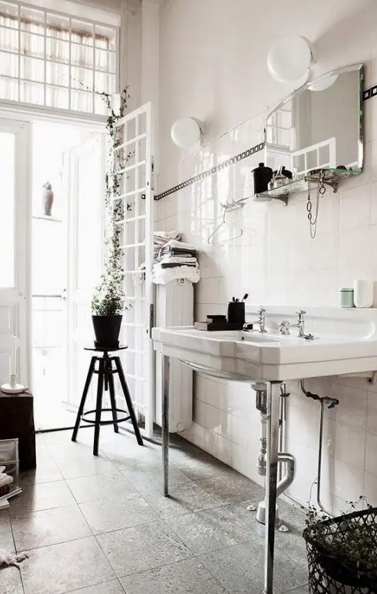 a vintage Nordic bathroom done in a neutral color scheme, a vintage stool, sink and a mirror with a shelf