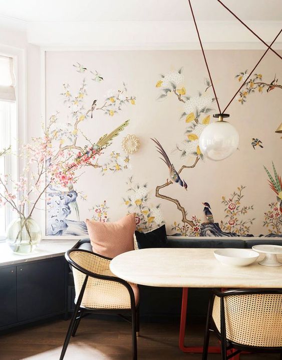 an elegant dining space with a gorgeous wall mural, with blooms and birds that takes over the whole space