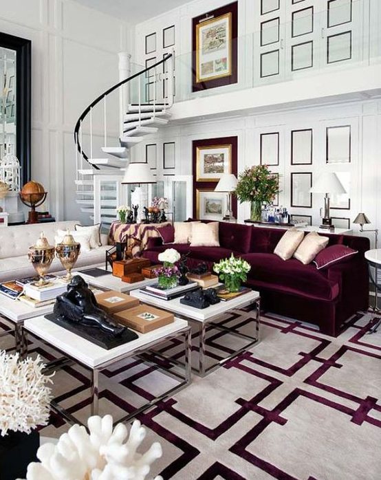 a beautiful living room with white paneled walls, a creamy and a purple sofa, a cluster of coffee tables and a printed white and purple rug