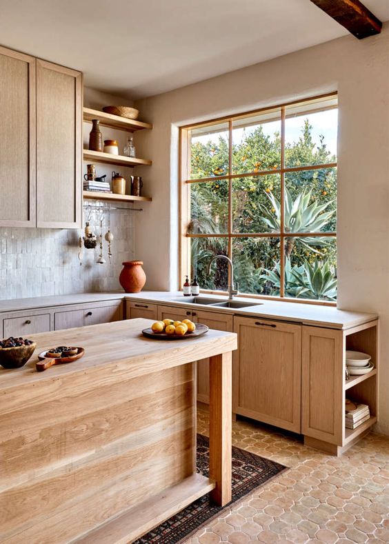 a beautiful modern rustic kitchen with stained cabinetry, butcherblock countertops, white Zellige tiles and a terracotta tile floor