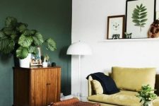 a cute boho living room with a green wall