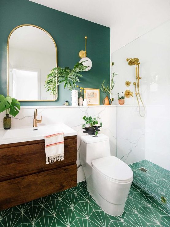 a bright mid century modern bathroom with a teal wall, an emerald print tile floor, a stained vanity and touches of gold