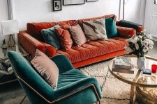 a charming living room with a bold burnt orange sofa, a teal chair and matching pillows plus a lovely gallery wall