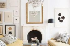 a chic living room with a non-working fireplace, a monochromatic gallery wall, a crystal chandelier and a duo of light yellow sofas