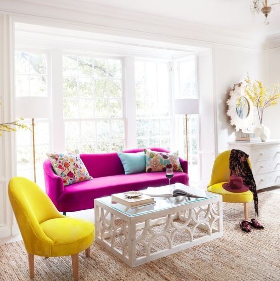 a chic neutral living room in modern farmhouse style, with a hot pink sofa, sunny yellow chairs, a glass table and colorful pillows