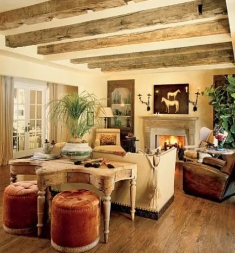 a chic rustic space with wooden beams on the ceiling, a refiend fireplace and shabby chic furniture