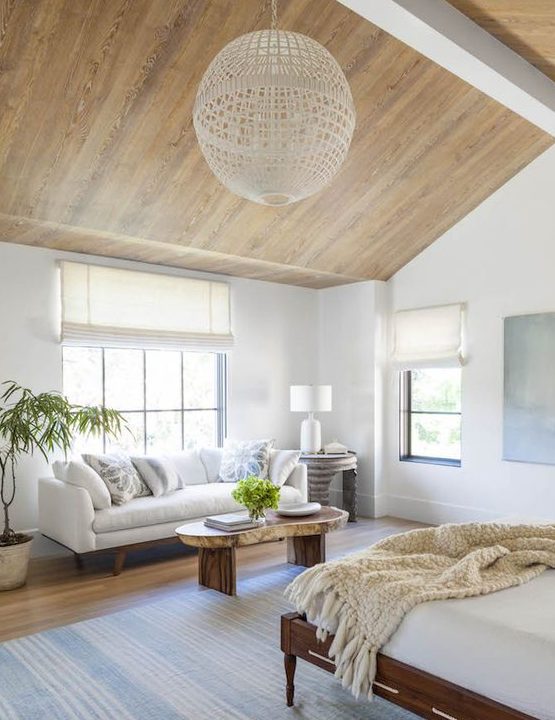 a comfy sofa by the window and a coffee table is a cool relaxing space to rock in the coastal bedroom