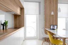 a contemporary Scandi kitchen with white cabinets and an additional row of stained wood ones plus matching countertops