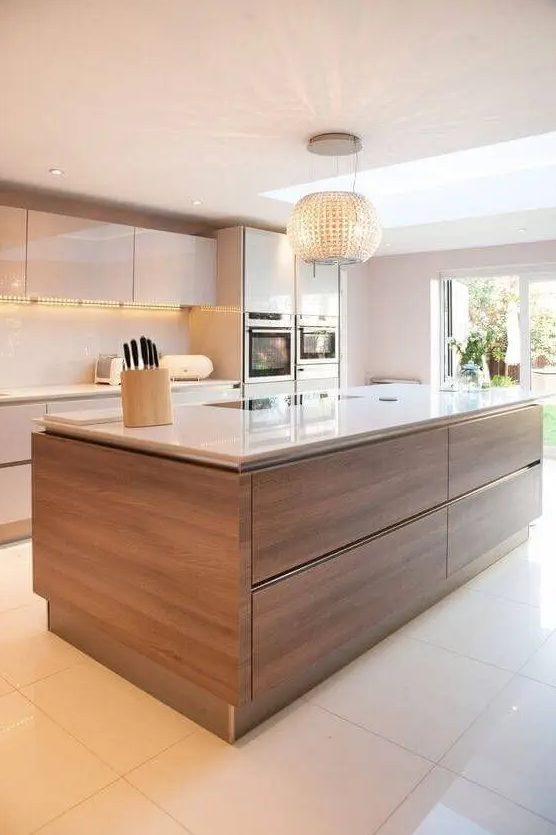 a contemporary kitchen with sleek white cabinets and a rich stained kitchen island, a sleek white countertop and a backsplash