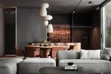 a contemporary space with a concrete ceiling and walls, an amber dining zone, a grey sofa and a low coffee table