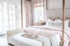 a glam bedroom with an accent wall, a frame bed with blush bedding, a creamy bench, checked curtains is amazing