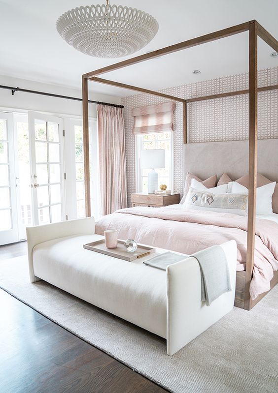 a glam bedroom with an accent wall, a frame bed with blush bedding, a creamy bench, checked curtains is amazing
