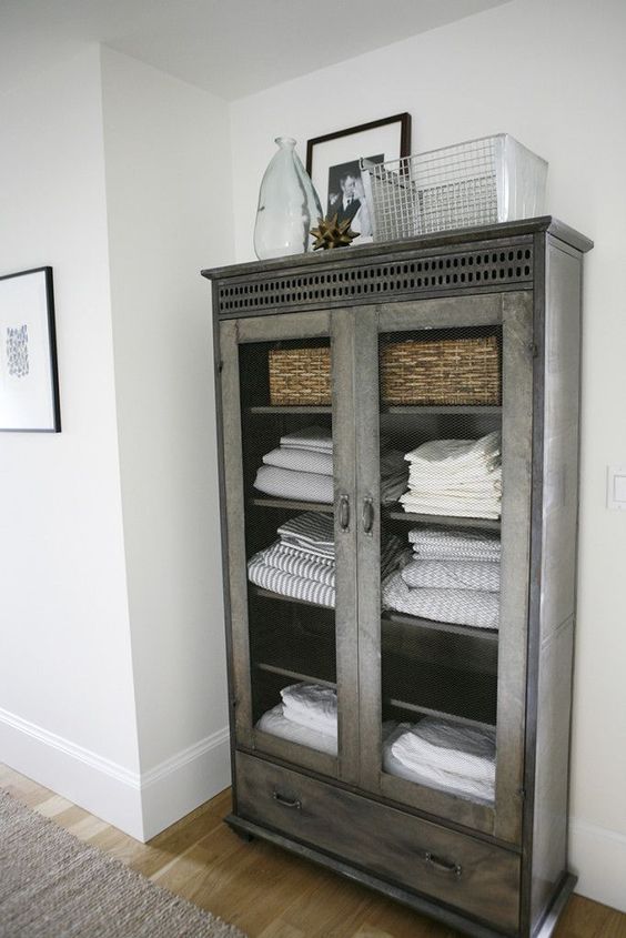 a grey shabby chic armoire for storing towels and bedding is a chic solution for a shabby chic or vintage bedroom