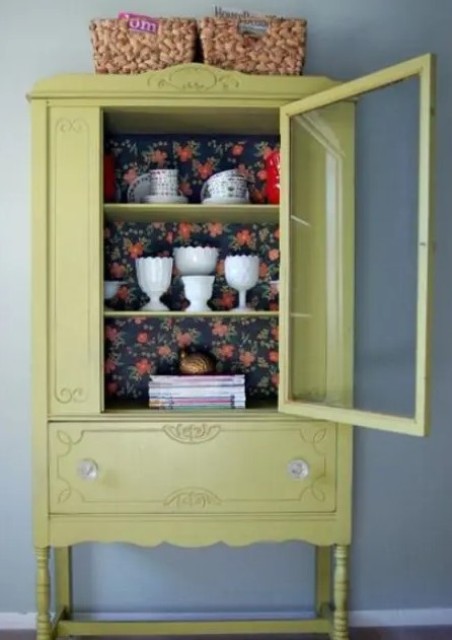 a light mustard color cupboard with dark floral wallpaper for a contrast is a beautiful addition to a vintage space and it can add vintage charm to the space