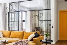 a lovely contemporary space with a warm yellow sectional, a black able and some black and white pillows
