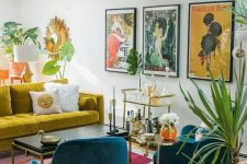 a maximalist living room with a mustard sofa, teal chairs, a colorful rug and a bold gallery wall plus potted plants