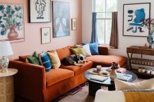 a stylish maximalist living room design with an orange sofa