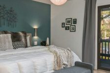 a mid-century modern bedroom with a teal statement wall, a grey bench and a globe pendant lamp