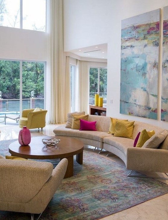 a mid-century modern living room with a curved sofa, colorful pillows and a watercolor artwork for more color
