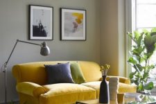 a mid-century modern living room with grey walls, a lemon yellow vintage sofa, a small gallery wall, a black low table and potted plants