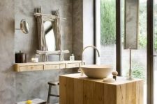 a modern rustic bathroom of concrete and light-colored wood, the wood brings a cozy feel