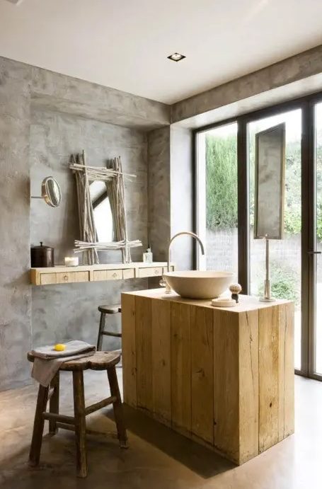 a modern rustic bathroom of concrete and light-colored wood, the wood brings a cozy feel
