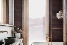 a modern rustic bathroom with a wooden vanity composed of two shelves, an oval tub, walls and the ceiling clad with wood and a large window