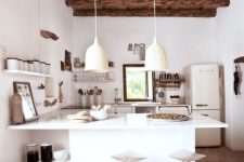 a modern rustic kitchen with a wodoen ceiling and beams, white cabinets, white woven pendant lamps and tall stools