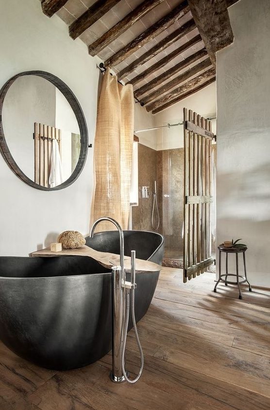 a modern rustic meets industrial bathroom with a stone tub, burlap curtains and much wood in decor is a very chic space