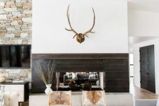 a modern rustic space with jute, fur, wood and stone in decor plus cowhide chairs