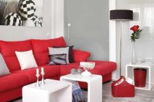 a monochromatic contemporary living room in white and light grey, with a bold red sofa and other touches for a brighter look