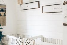 a neutral boho twin nursery with white walls, white cribs, macrame hangings, printed textiles and some greenery