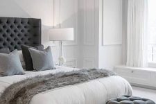 a pair of graphite grey tufted stools by the foot of the bed that match the bed and textiles
