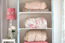 a pastel blue cupboard with no doors for storing blankets and bedspreads is a lovely idea for a vintage or shabby chic bedroom or living room