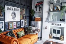a quirky living room with a black paneled wall, an orange sofa, a mini hearth and a mirror, a whimsy gallery wall and a low table