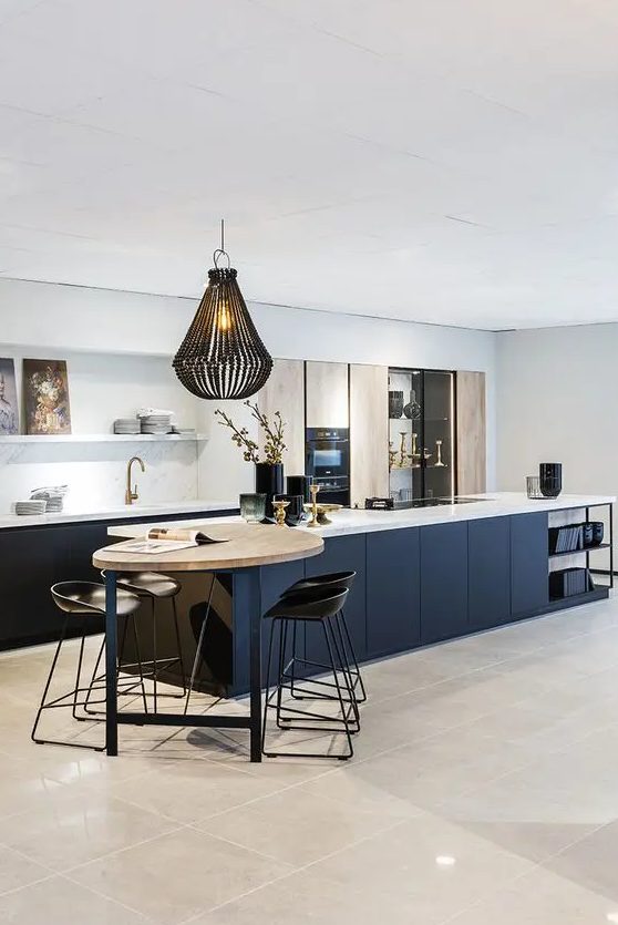 a refined contemporary kitchen with navy lower cabinets and a kitchen island, ligth stained doors, open shelves and a small meal zone