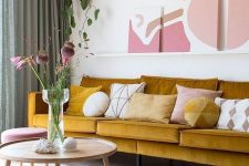 a refined living room with a mustard sofa, a ledge gallery wall, touches of pink and mauve for a very elegant and chic look