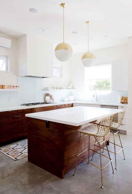 a rich-stained mid-century modern kitchen with white countertops, a white hood and pendant sphere-shaped lamps