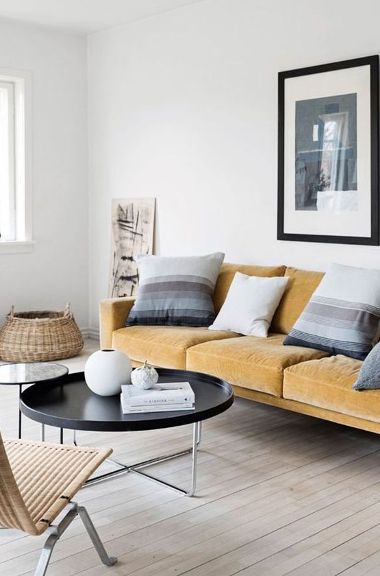a serene Scandinavian living room with a light yellow sofa, striped pillows, round tables and a rattan lounger is wow