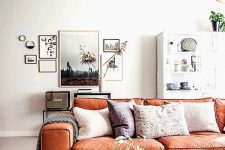 a serene Scandinavian living room with neutral furniture, a chic gallery wall and an orange leather sofa with boho pillows is amazing