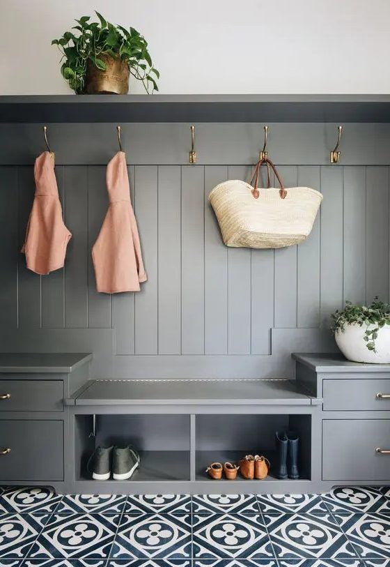 a slate grey mudroom unit with drawers, open storage units, hooks and a shelf is a stylish idea