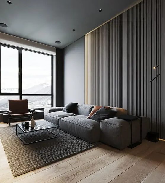 a slate grey wooden slab accent wall, a grey sofa with black pillows, a concrete ceiling, a rug and a black coffee table